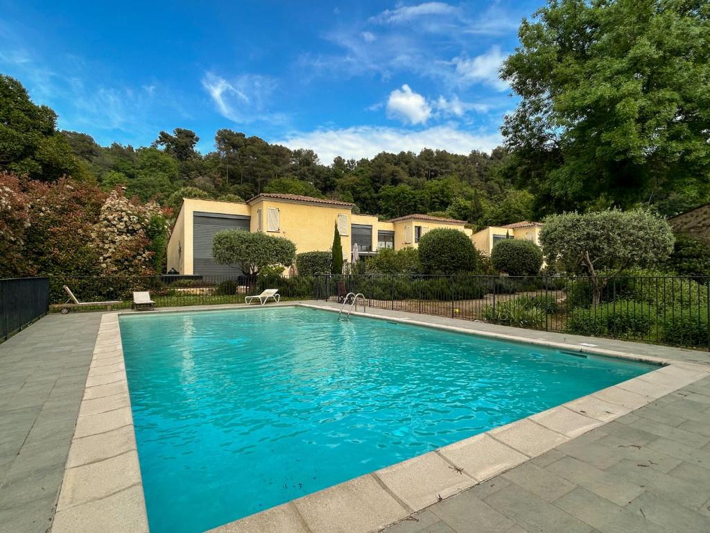une piscine avec de l'eau bleue dans une cour dans l'établissement La Bergerie - Modern villa with pool in private domain, à Saint-Paul-de-Vence