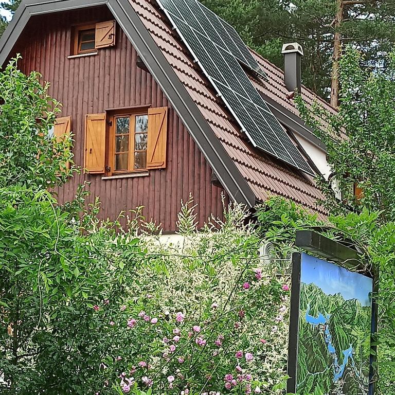 a brown house with a window and some bushes at Plitvice Studio Apartments in Rudanovac