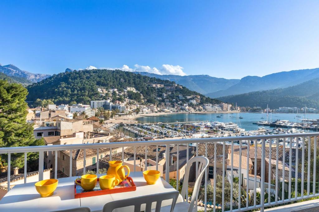 Un balcón con una mesa con jarrones amarillos encima. en Neptuno 1 Simple Apartment in Port de Soller, en Sóller