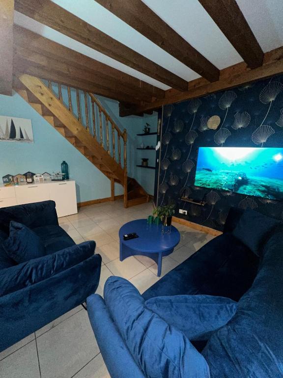 un salon avec un canapé bleu et une télévision dans l'établissement Le 8 appartement - Le Duplex III - parking sur demande, à Mâcon