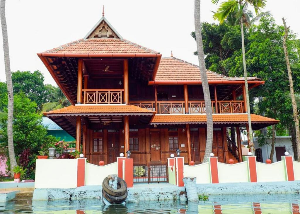 une maison sur l'eau à côté de l'eau dans l'établissement AquaPalace-The heritage homestage, à Champakulam