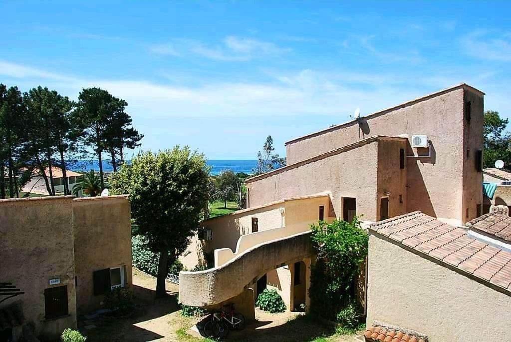 un bâtiment avec un escalier devant lui dans l'établissement Studio Corse avec acces direct à la plage La Liscia, à Calcatoggio