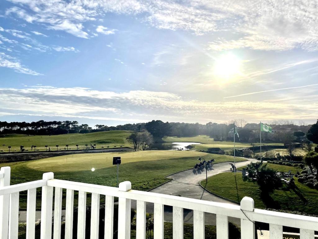 une vue d'un terrain de golf avec une clôture blanche dans l'établissement Le Perchoir du Green - Pool - Golf, à Talmont-Saint-Hilaire
