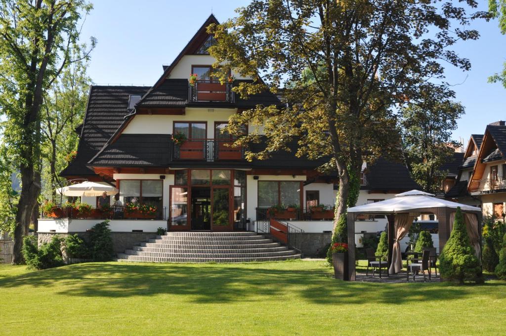 a house with a lawn in front of it at Willa Kmicic in Zakopane