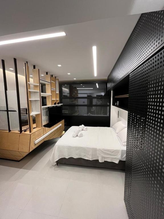 a bedroom with a white bed and a black wall at Old Town Flat in Patra