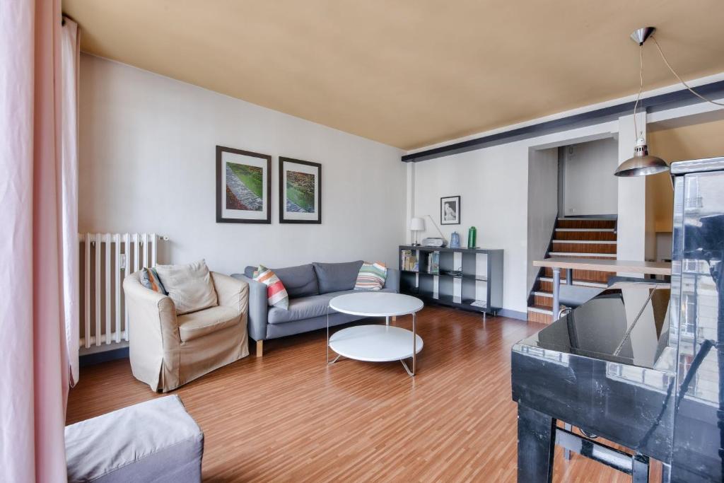 un salon avec un canapé et une table dans l'établissement Stunning 2BR Flat near Place des Vosges, à Paris