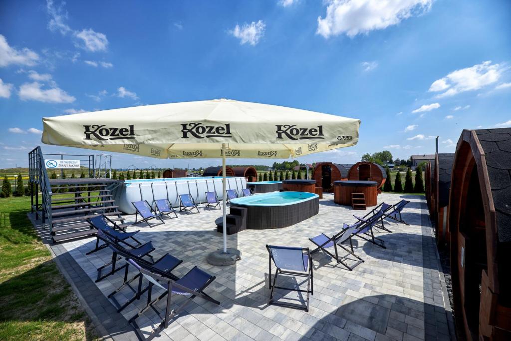 扎托尔Fantazja Resort Zator的带椅子、桌子和遮阳伞的露台