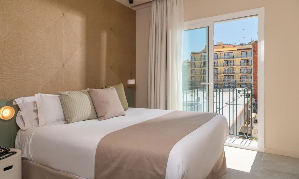 a bedroom with a large bed and a large window at AQUA Hotel Bertran Park in Lloret de Mar