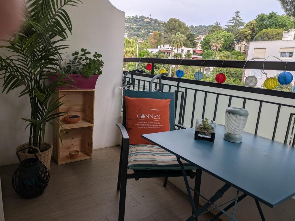 d'une table bleue et d'une chaise sur un balcon avec vue. dans l'établissement Cannes Isola Bella entre mer et montagne, à Cannes