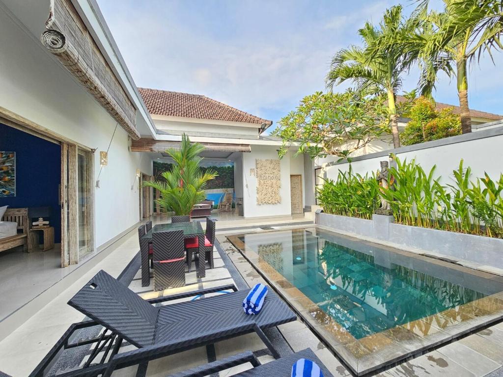 a villa with a swimming pool and patio furniture at Villa Ohana 2 BR Family villa with pool in Umalas in Kerobokan
