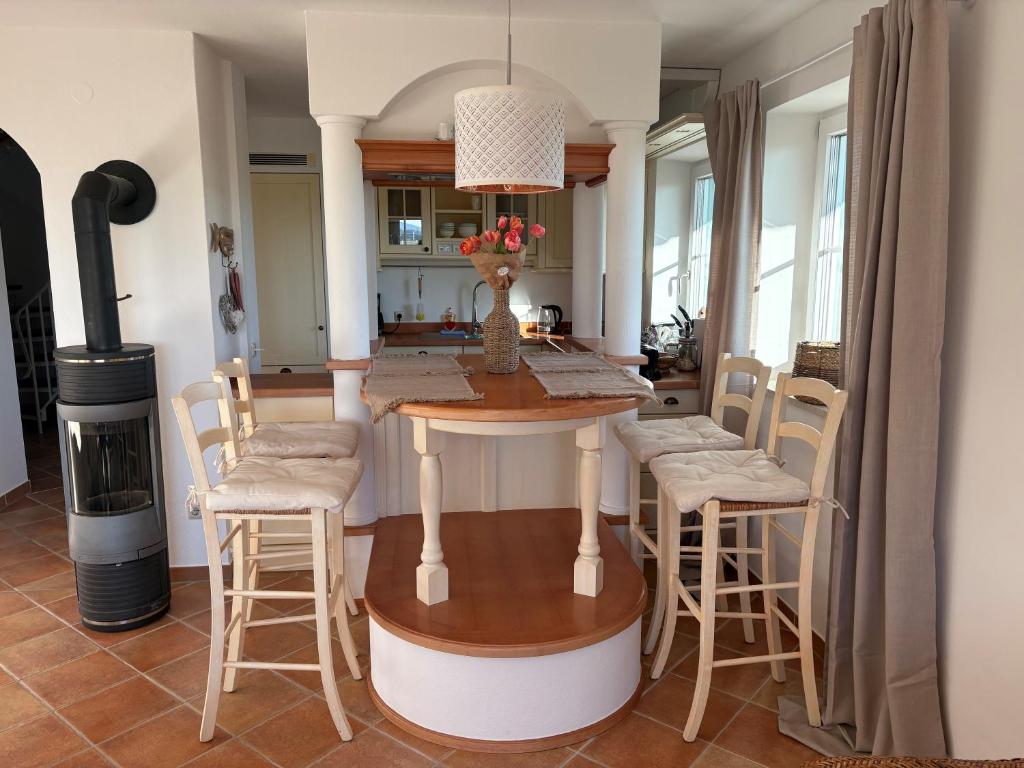 a kitchen with a table and stools in a room at Ferienwohnung mit Herz Chiemsee in Chieming