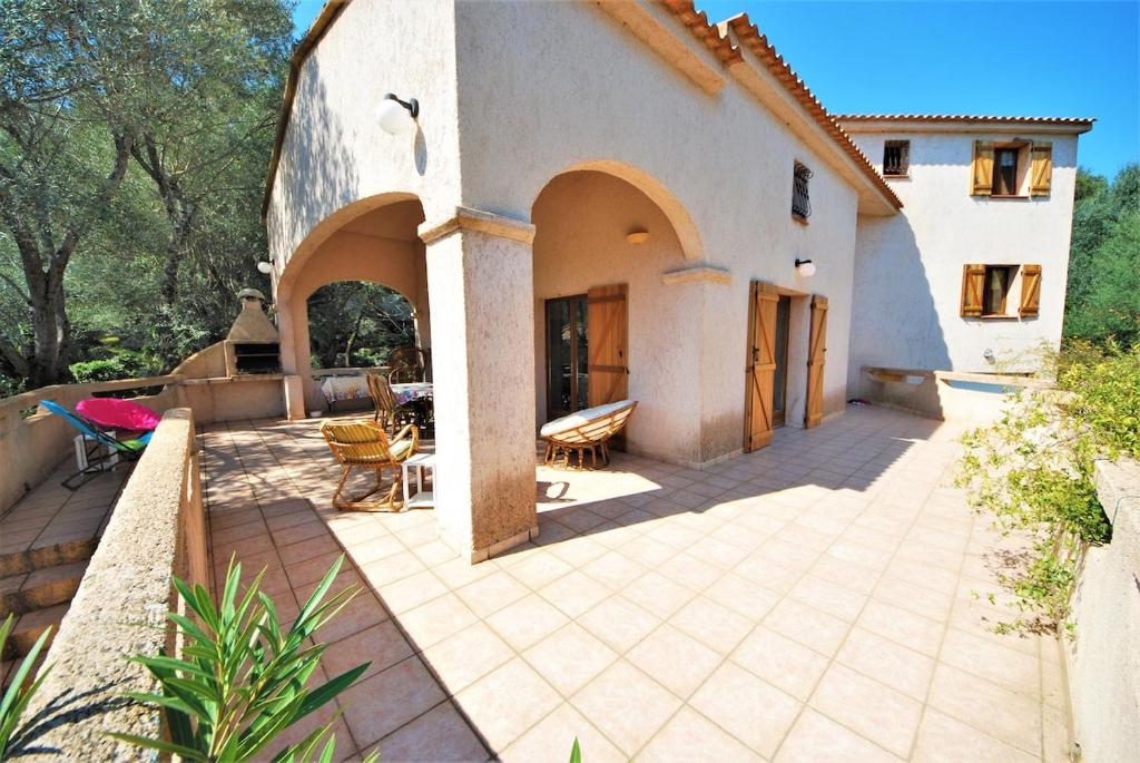 un patio d'une maison avec une table et des chaises dans l'établissement Maison Famiglia Sérénité et nature, à Porto-Vecchio