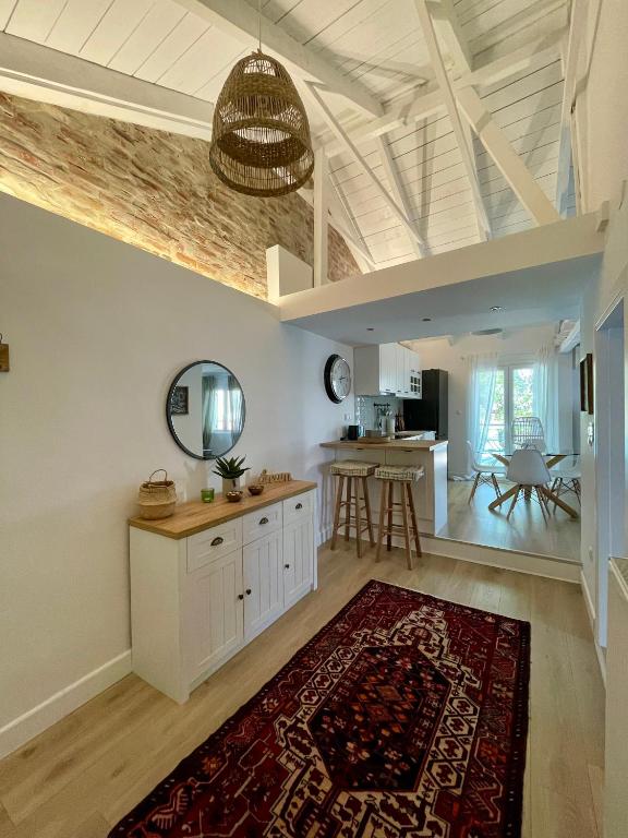 a kitchen with white cabinets and a red rug at Plane Tree House in Próti