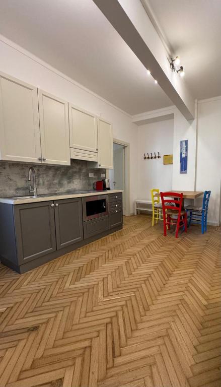 a kitchen with a wooden floor and a table with chairs at Aro's House in Cremona
