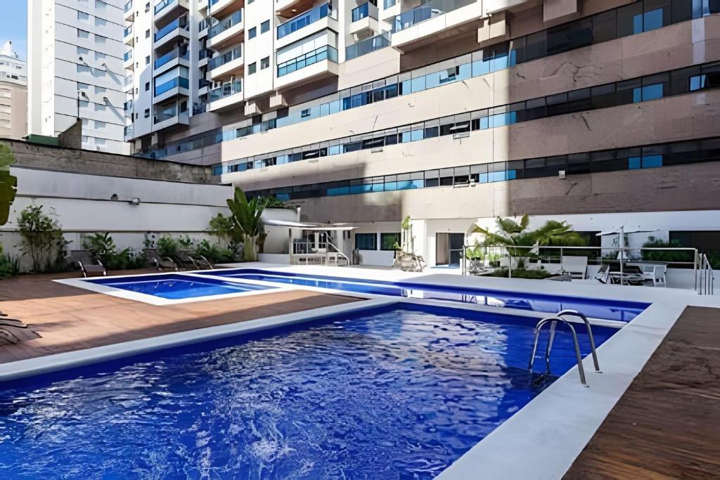 a swimming pool in front of a building at SHB - The Jewel Pitangueiras with complete leisure in Guarujá