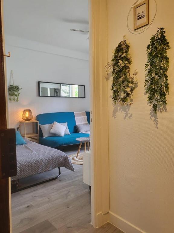Cette chambre comprend un lit et un canapé bleu. dans l'établissement Appartement Juan Les Pins à 2 min de la plage, à Antibes