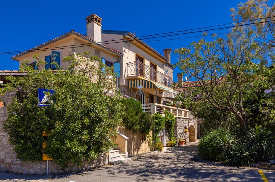 a large house on a street with trees at Holiday apartment WATERFRONT by the sea in Klimno