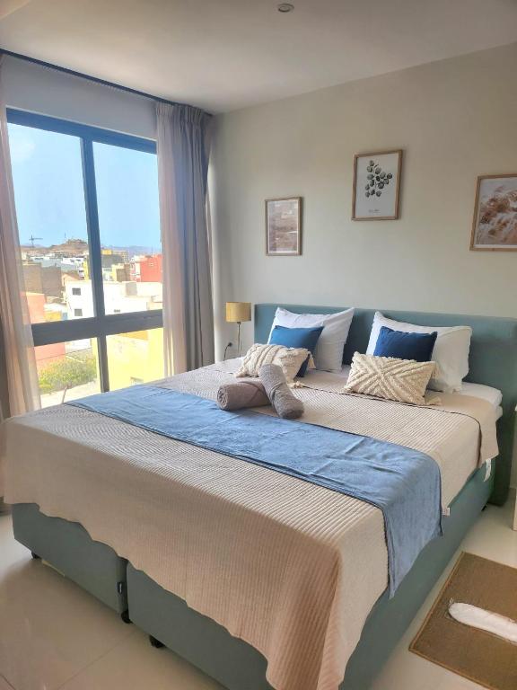 un letto grande in una camera da letto con una grande finestra di Boa Mindelo Azul a Mindelo