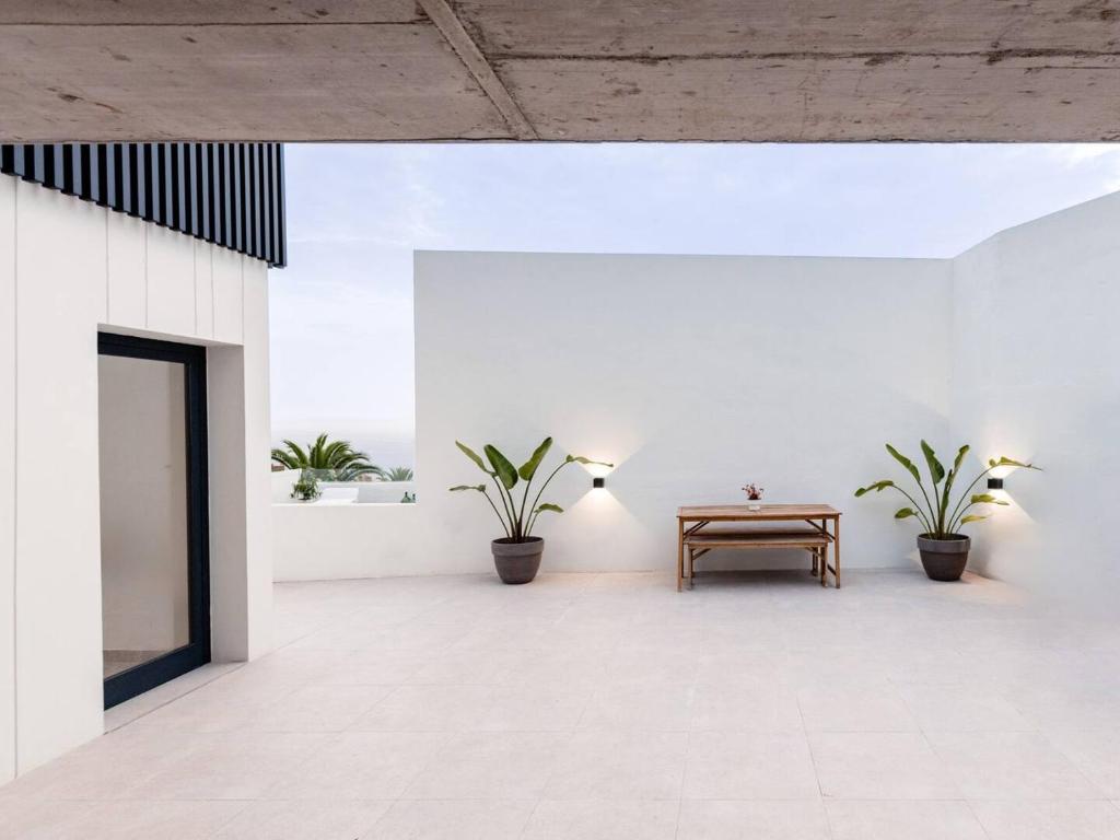 ein Zimmer mit einem Tisch und zwei Topfpflanzen in der Unterkunft Sunset Horizon Hideaway & Terrace, Santa Úrsula in Santa Úrsula