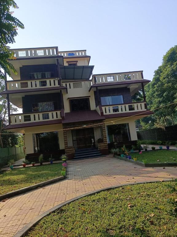 a large building with a driveway in front of it at Resort Morning Glory in Lataguri