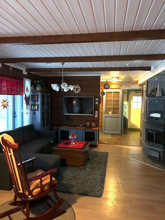 a living room with a couch and a table at Traditional Lapland 2BR House with Private sauna in Nuupas