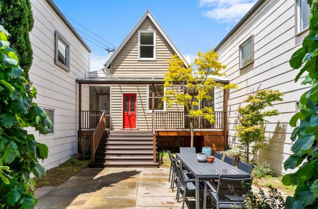 a house with a red door and a table at Hobart Heritage Home - Close to CBD & Airport in New Town