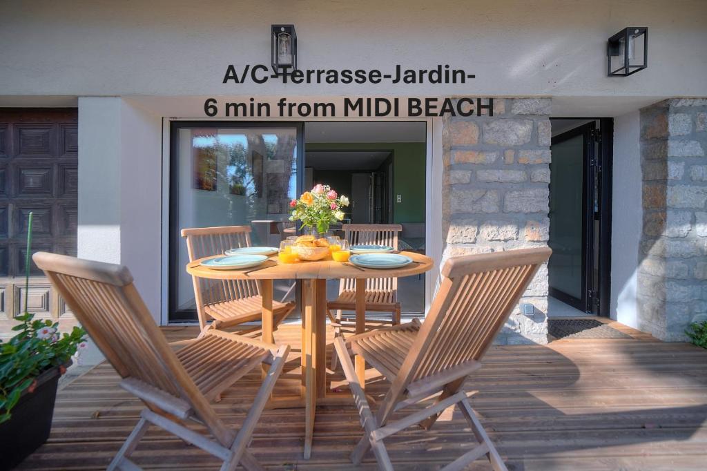 une table et des chaises en bois sur une terrasse dans l'établissement A2B241 T3 REZ-de-JARDIN PROCHE PLAGES, à Cannes