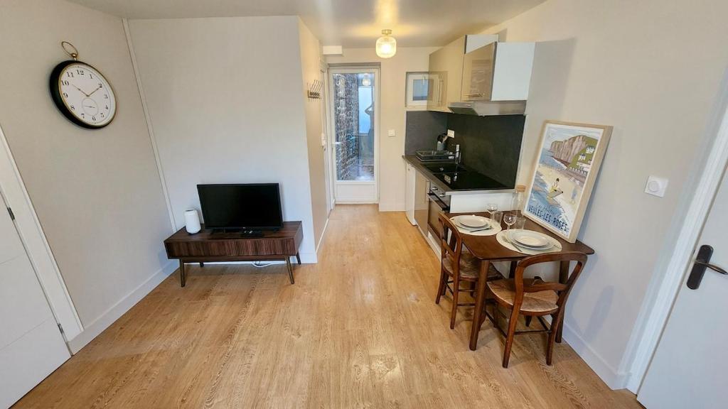 a kitchen and dining room with a table and a clock at Le Moulin in Veules-les-Roses