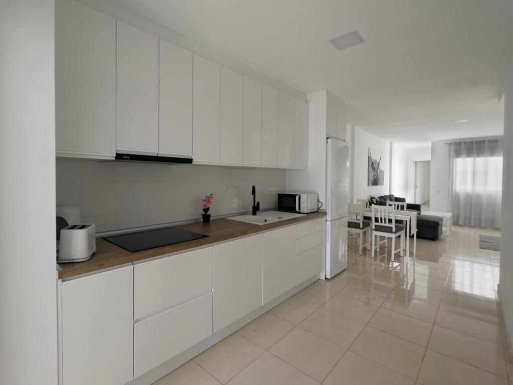 cocina blanca con armarios blancos y encimera en Residencial Amber III - Apartamento nuevo, amplio y cómodo, en Vecindario