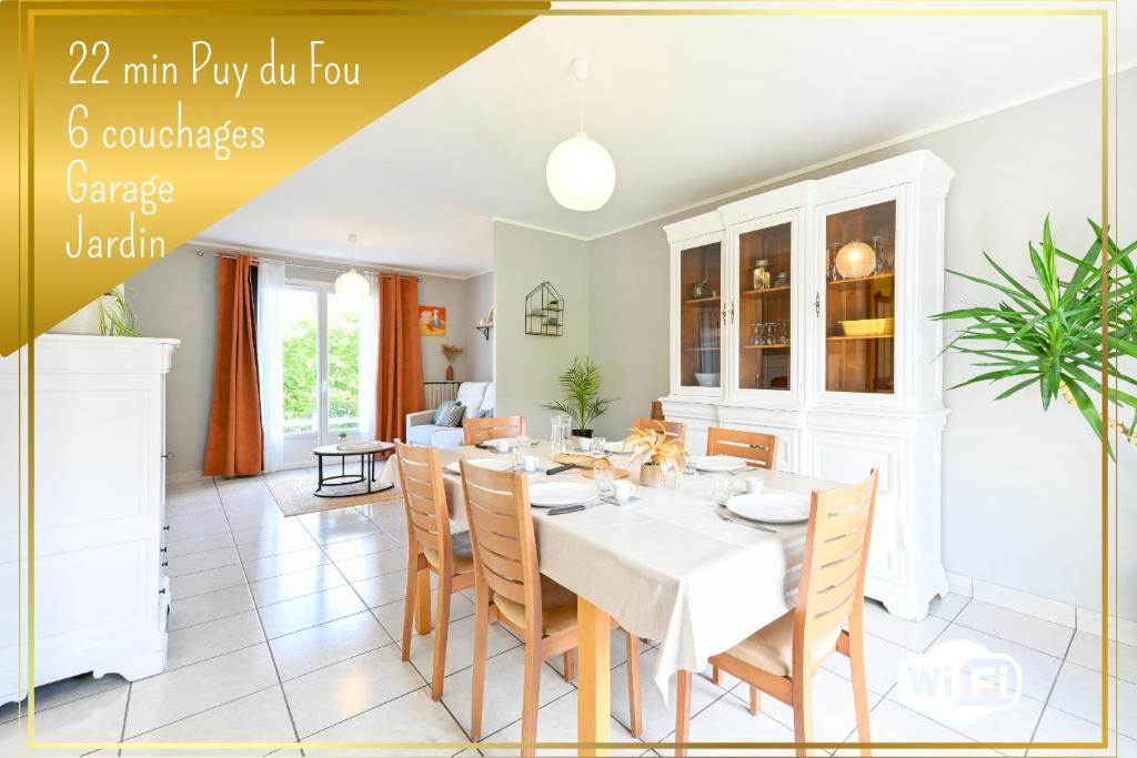 una sala da pranzo con tavolo e sedie bianchi di Le Cocon Perché - Ambiance Pastel et Jardin Arboré a Cholet