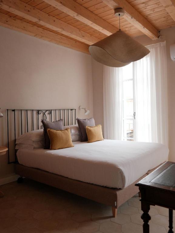 Una cama grande en un dormitorio con una ventana grande. en Lakeview Jonny house on the roofs, en Lezzeno