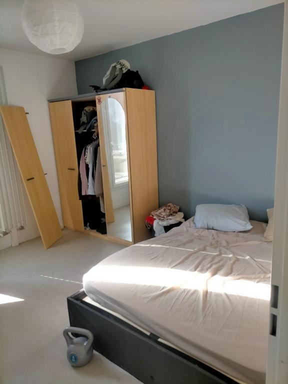 une chambre avec un lit et un miroir dans l'établissement quiet stay, à Cergy