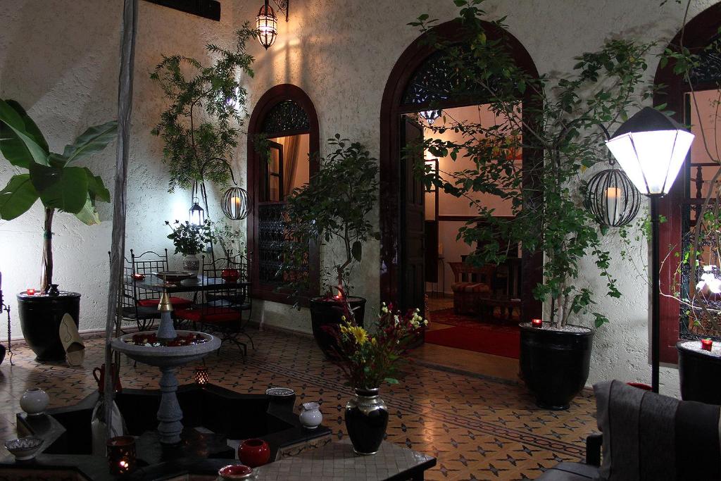 una stanza con piante in vaso alle pareti e un corridoio di Riad Jomana a Marrakech