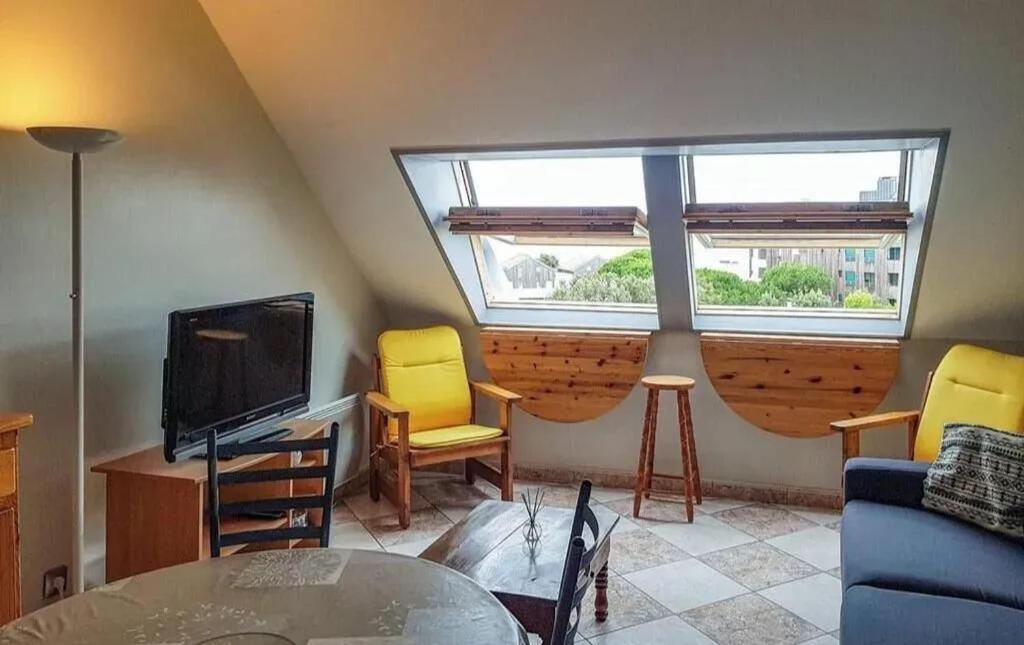 d'un salon avec des chaises jaunes et une télévision. dans l'établissement Charmant appartement à La Rochelle 41 m² avec parking, à La Rochelle