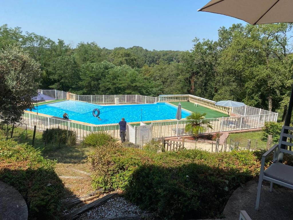 une grande piscine entourée d'une clôture. dans l'établissement Villa émeraude, à Cublac