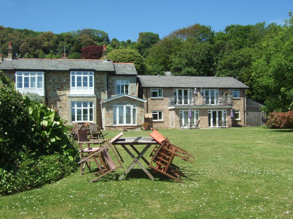 a house with a table and chairs in front of it at Woodcliffe Sea-view Apts in Ventnor