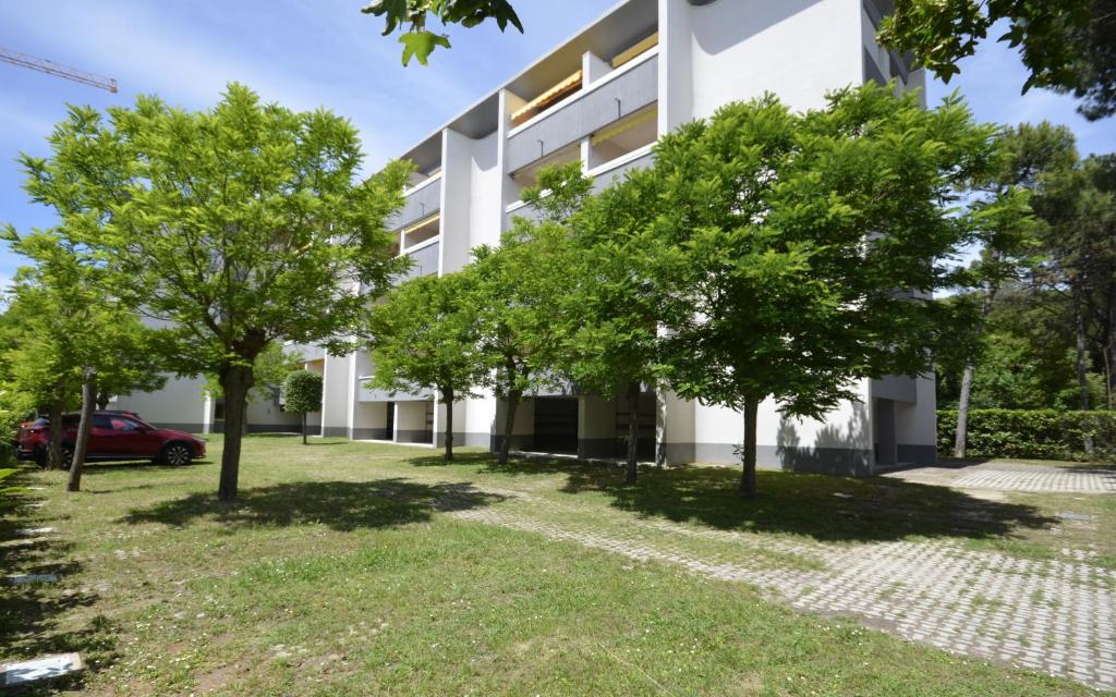 a building with trees in front of it at Appartamenti La Quercia in Bibione