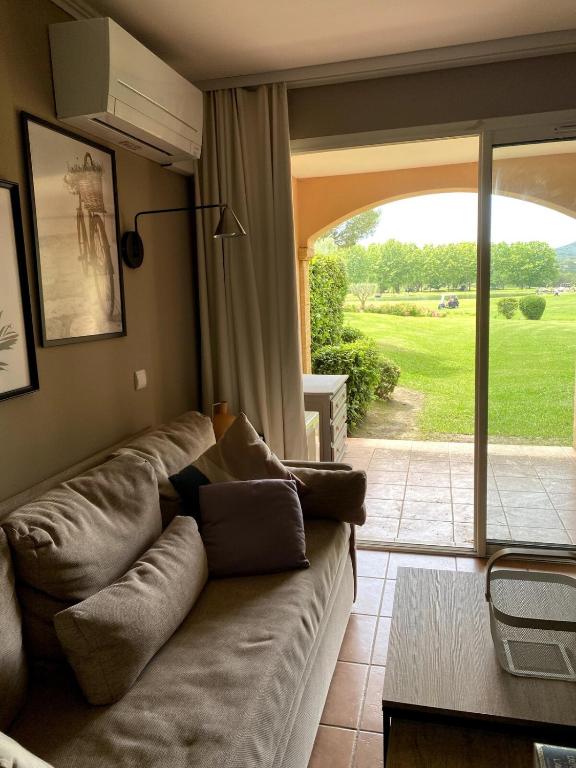 un salon avec un canapé et une porte coulissante en verre dans l'établissement Élégant appartement sur le Golf de Pont Royal, à Mallemort