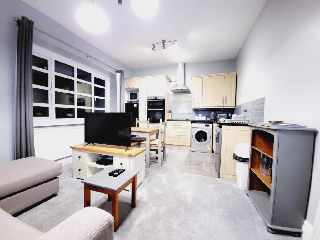 a kitchen and living room with a couch and a table at 2 bed flat Centre Swansea in Swansea