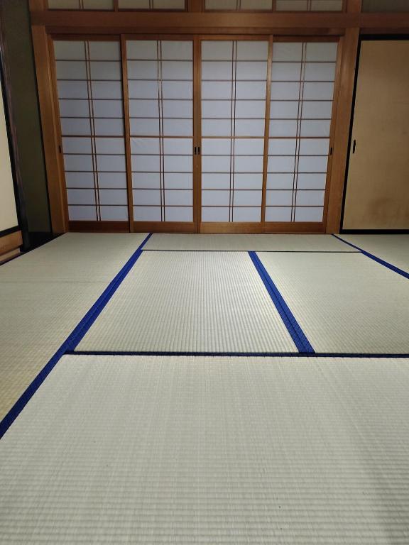 an empty room with two garage doors and a floor at はなおか in Takayama