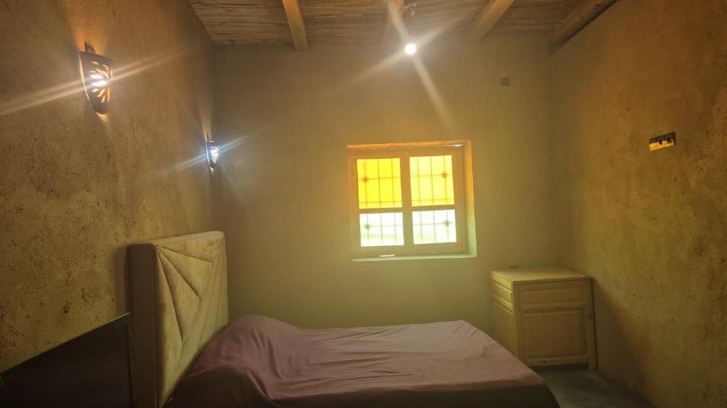 una piccola camera da letto con un letto e una finestra di Dar badiawarda ad Azilal