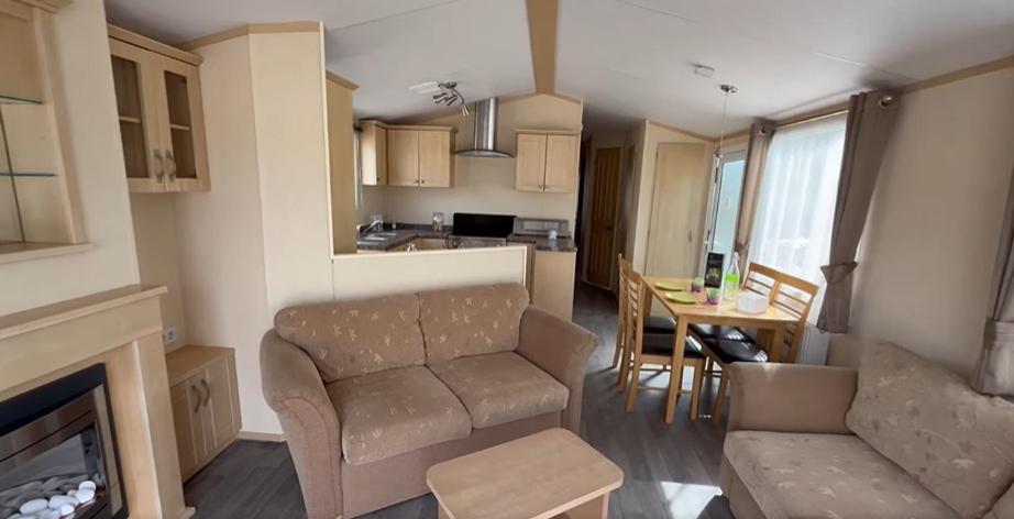 un salon avec un canapé et une salle à manger dans l'établissement Mobil 6 Places direct sur la plage, à Camiers