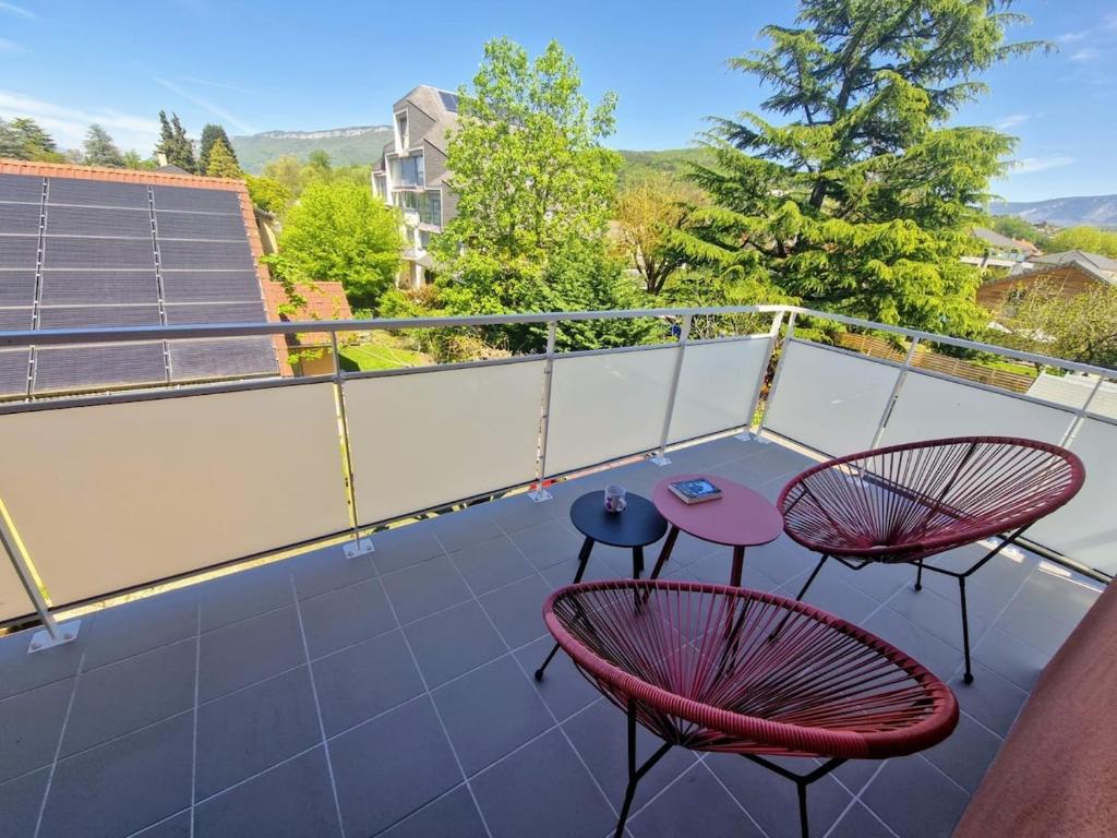 d'un balcon sur le toit avec 2 chaises et des tables. dans l'établissement T3 spacieux, proche du lac et du grand port avec garage, à Aix-les-Bains