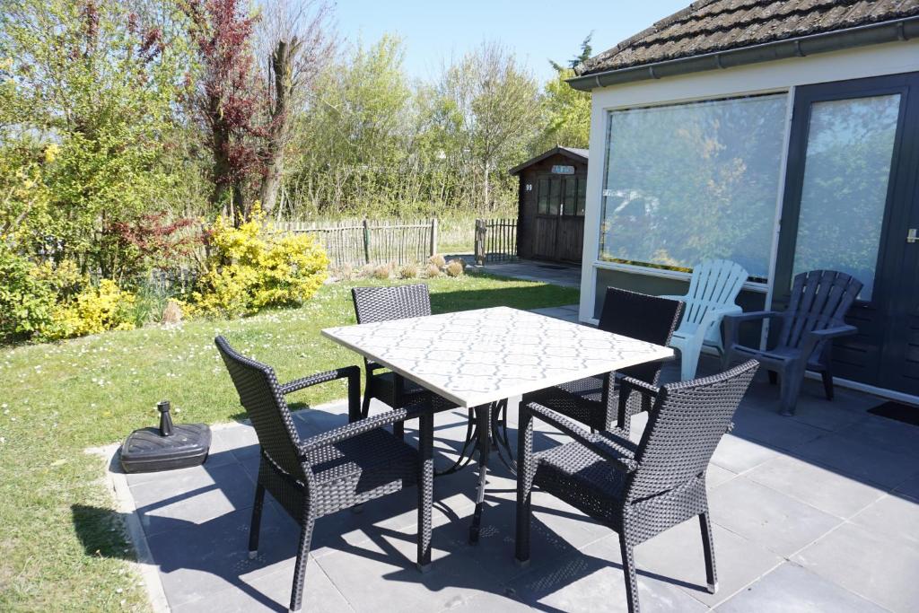 a table and chairs sitting on a patio at Kustverhuur, Park Schoneveld, Duinroos 099 in Breskens