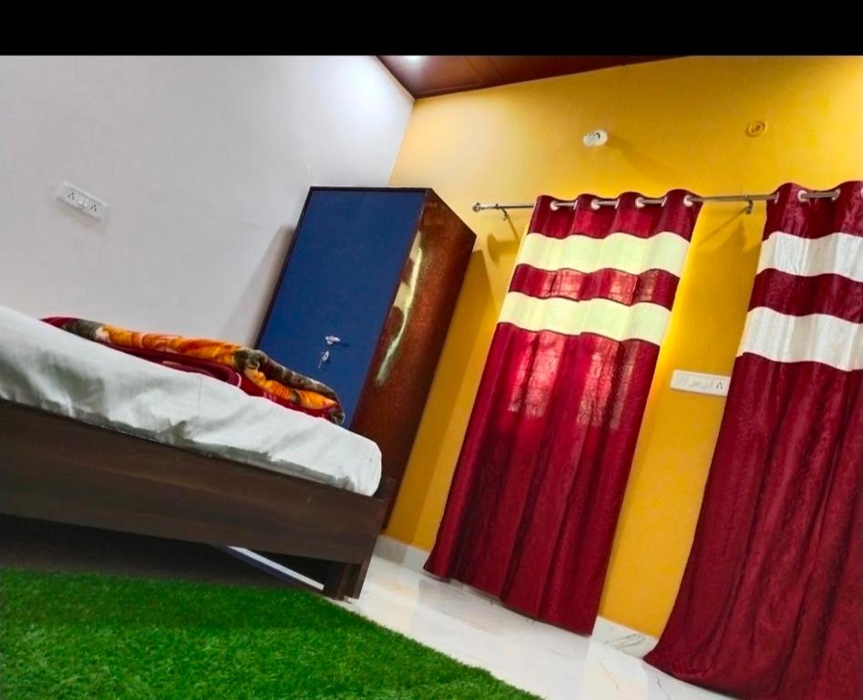 een kamer met een bed, gordijnen en een groen tapijt bij Corbett hill center river home stay in Lansdowne