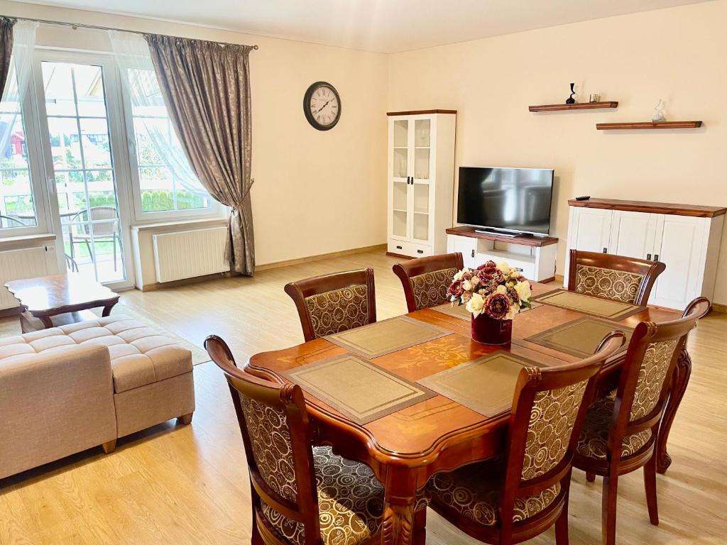 a living room with a table and a couch at Svečių Apartamentai Vanagupėje in Palanga