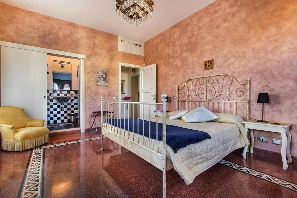 a bedroom with a bed and a chair at Cathedral City Center Palermo 3 in Palermo