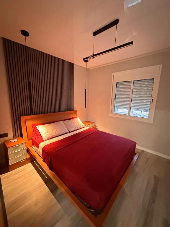a bedroom with a large red bed with a window at Villa Mont-roigh in Tarragona
