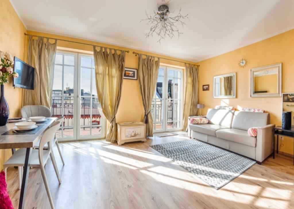 una sala de estar con un sofá y una mesa en Apartamenty Zachód Słońca Mi Casa Holidays, en Mielno