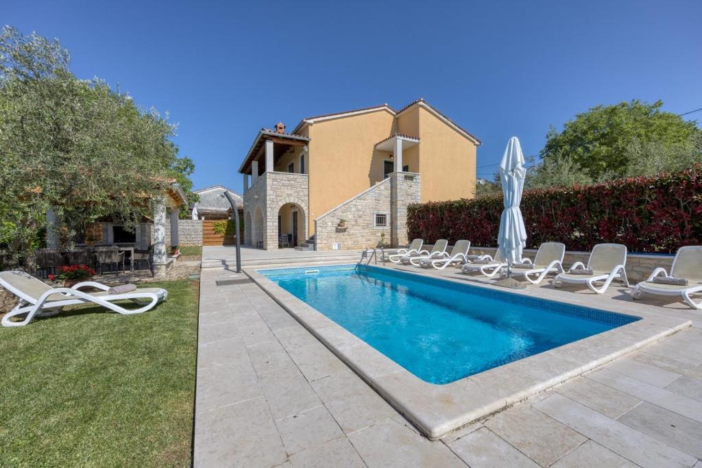 basen z leżakami i dom w obiekcie Villa Ladonja with Private Pool and Sauna w mieście Marasi